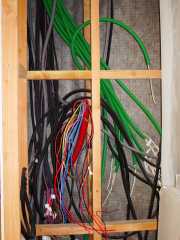 Spaghetti of electrical conduits behind the circuit breaker box position.